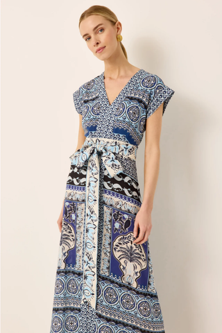 Woman wearing a patterned dress against a plain background