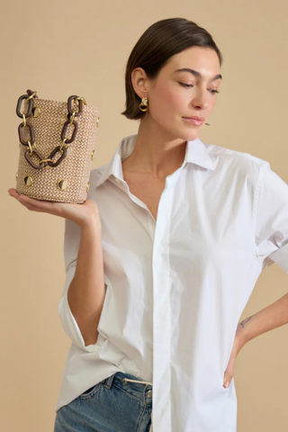 Brackish Greenwich Bucket Bag with woven textured exterior, gold bezel accents, feather inlays, and removable chain straps