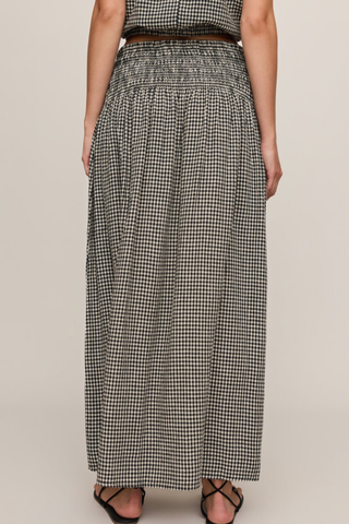 Model wearing the Z Supply Brooke Gingham Skirt in Black with a flowy maxi silhouette and smocked waistband.