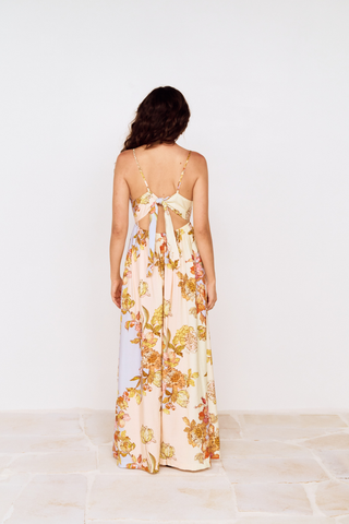 Model wearing the MINKPINK Fiore Tie Back Maxi Dress in Pastel Floral featuring a strapless neckline, flowing maxi silhouette, tie-back detail, and soft pastel floral print.