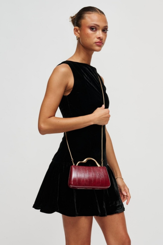Rue Aveline Nichelle Clutch in Burgundy featuring textured vegan leather, a structured frame silhouette, gold-tone top handle, and removable chain strap.