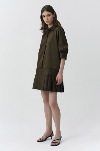 SIMKHAI Regina Mini Dress in dark olive featuring a pointed collar, short puff sleeves, concealed button front, and pleated mini hem.