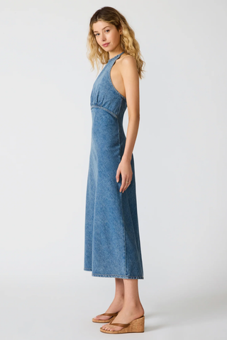 Woman wearing a blue denim dress on a white background