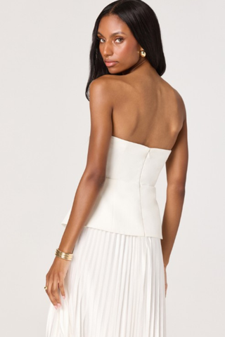 Woman wearing a white strapless midi dress with structured bodice and pleated skirt from ASTR on a white background.