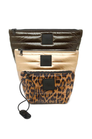 Think Royln Travel Trio set of three quilted pouches in chocolate brown, pearl, and leopard print.