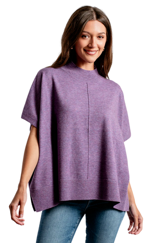 Woman wearing a purple poncho over a white background