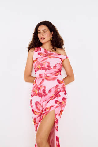 Model wearing MINKPINK Bianca Mesh Midi Dress in Pink Floral featuring an asymmetrical off-the-shoulder neckline, ruched mesh fabrication, and side slit detail