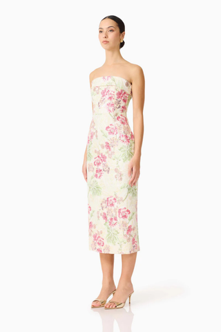 Woman wearing a strapless floral dress on a white background
