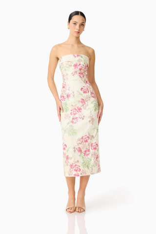 Woman wearing a strapless floral dress on a white background