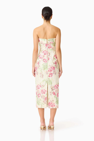 Woman wearing a strapless floral dress on a white background