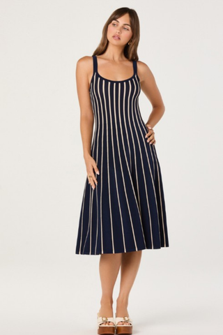 Model wearing the ASTR Irecia Sweater Dress in Navy Stripe featuring a scoop neckline, tank silhouette, soft knit fabric, and cream vertical stripes on a classic navy midi dress.