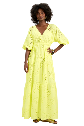 Model wearing the Trina Turk Arco Iris Dress in Citrus featuring pineapple eyelet embroidery, balloon sleeves, empire waist, and tiered maxi skirt
