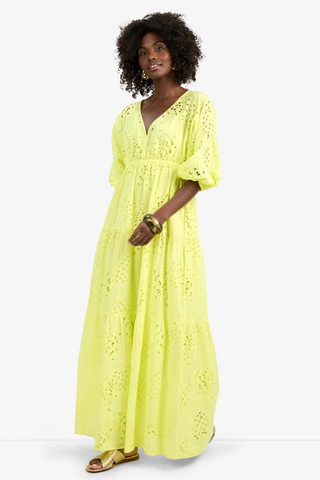 Model wearing the Trina Turk Arco Iris Dress in Citrus featuring pineapple eyelet embroidery, balloon sleeves, empire waist, and tiered maxi skirt
