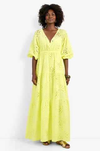 Model wearing the Trina Turk Arco Iris Dress in Citrus featuring pineapple eyelet embroidery, balloon sleeves, empire waist, and tiered maxi skirt