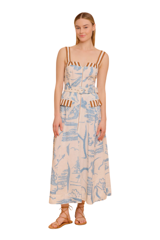 Model wearing the Olivia by Livro Foster Dress in Basket Trail, featuring a structured bodice, adjustable straps, full A-line skirt, side pockets, and a soft blue and neutral botanical print.