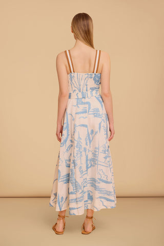 Model wearing the Olivia by Livro Foster Dress in Basket Trail, featuring a structured bodice, adjustable straps, full A-line skirt, side pockets, and a soft blue and neutral botanical print.