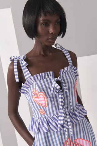 Celia B Kailen Dress in Multi featuring blue striped cotton fabric, colorful floral embroidery, ruffle trim, and tie shoulder straps