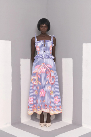 Celia B Kailen Dress in Multi featuring blue striped cotton fabric, colorful floral embroidery, ruffle trim, and tie shoulder straps