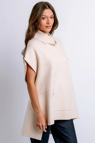 Kerisma Kanga Poncho in Ecru featuring a relaxed draped silhouette, high neckline, short sleeves, and side slit details.