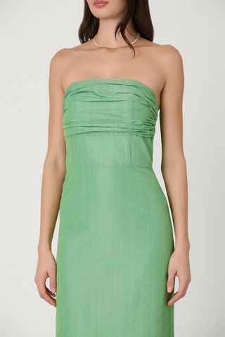 Strapless sage green midi dress with smocked ruched bodice and slim column silhouette, shown on model against white background.