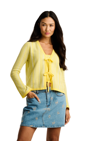 Butter yellow tie-front cardigan with ribbed knit and cropped fit styled with a denim mini skirt