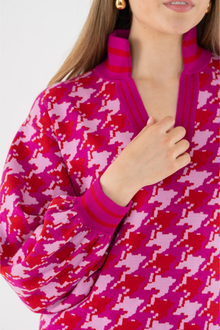 Emily McCarthy Lolli Sweater in Houndstooth featuring a vibrant pink and red houndstooth pattern, V-neckline, and long sleeves.
