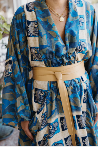 ADA Collection caramel wrap leather belt styled tied at the waist over printed blue dress